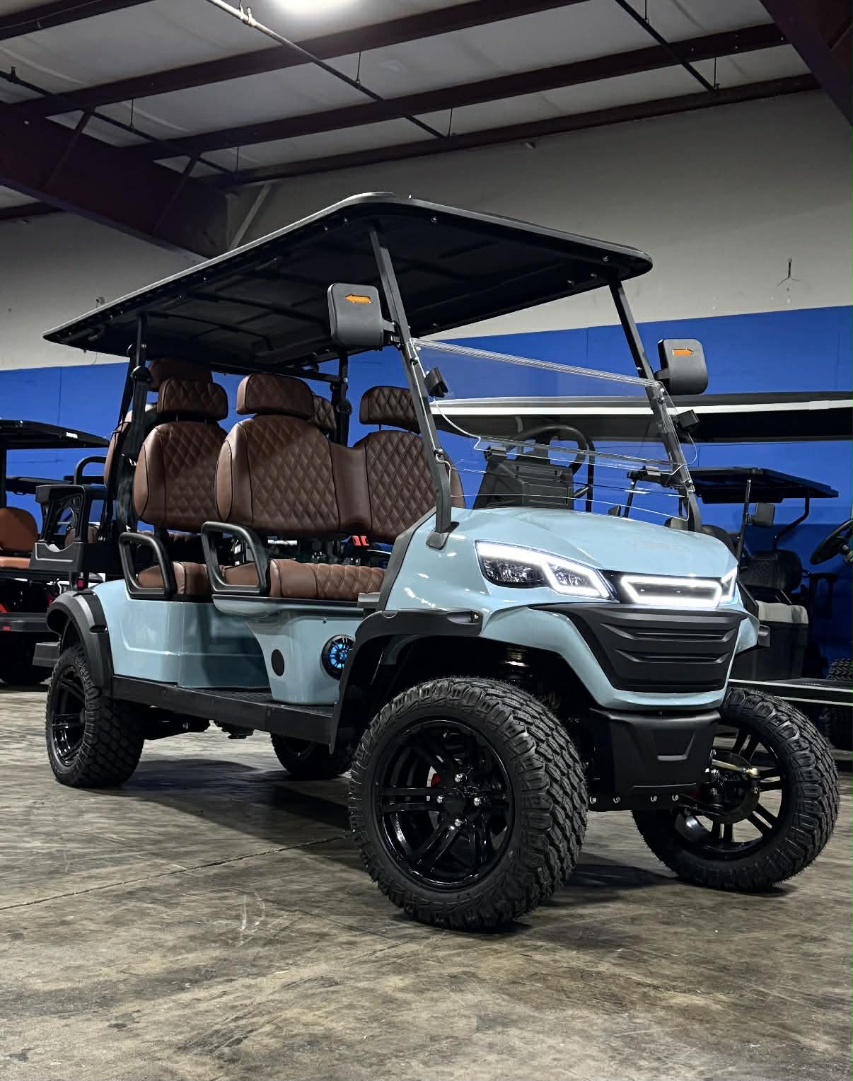 Teal Verdi 6-passenger lifted golf cart on the showroom floor