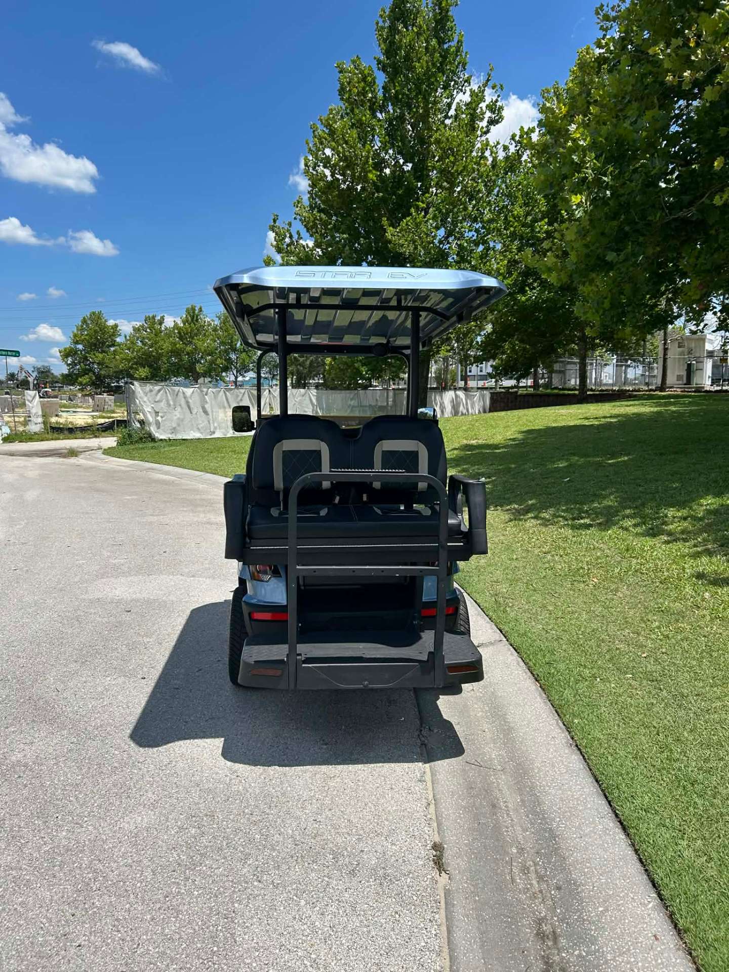 Rear view of light blue Star EV lifted golf cart with fold-down back seat
